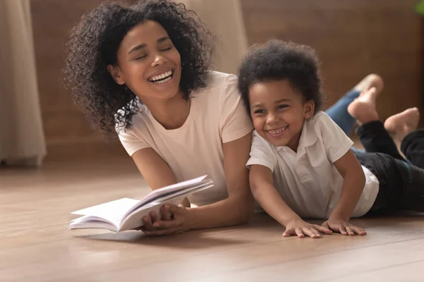 Glimlachen zwart mam en weinig zoon veel plezier lezen — Stockfoto