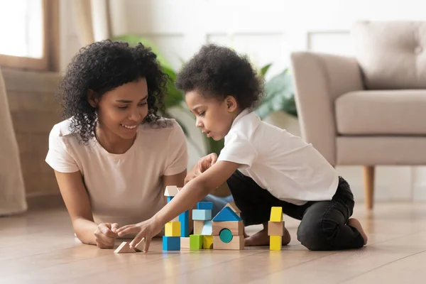 Sorrindo mãe negra se divertir brincando com o pequeno filho — Fotografia de Stock