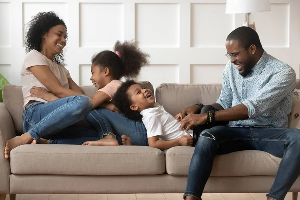 Lekfulla svarta föräldrar har roligt att leka med barn hemma — Stockfoto