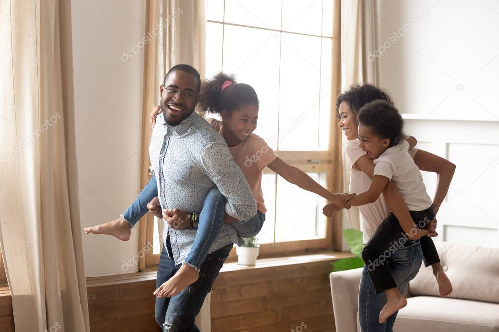 Happy black family have fun playing together at home