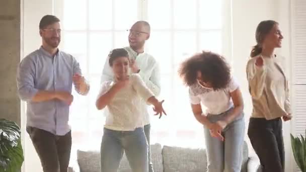 Diversos ativos amigos alegres dançando na sala de estar — Vídeo de Stock