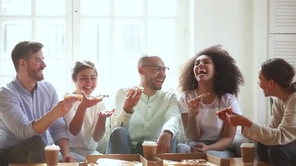 Diversos amigos alegres e alegres se reúnem comendo pizza e desfrutando da conversa — Vídeo de Stock