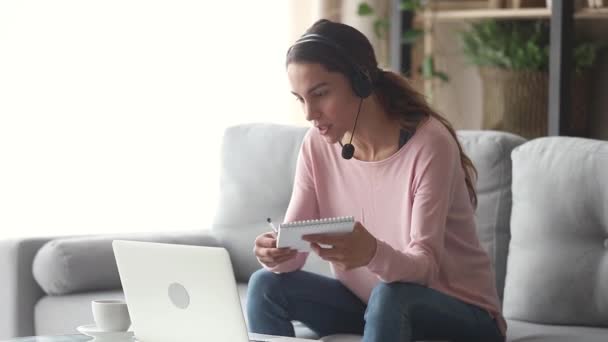 Mulher usando fone de ouvido com microfone aprendendo inglês com professor online — Vídeo de Stock