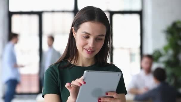 Smiling female worker involved in work on digital tablet — Stock Video