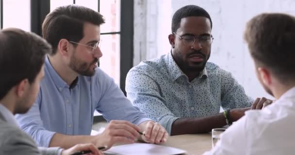 Serious young mixed race businessmen discussing partnership details. — Stock Video