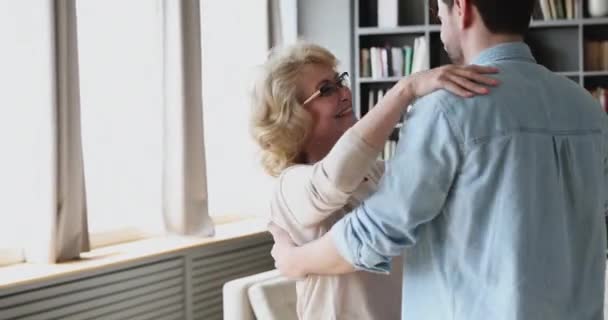 Middle aged woman teaching grownup handsome son dancing waltz. — Stock Video