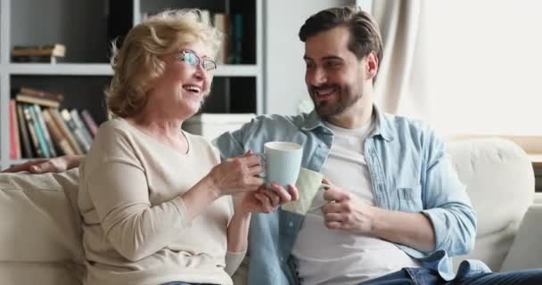 Opgewonden verschillende generaties familie chatten, genieten van 's morgens koffie. — Stockvideo