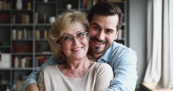 Portret szczęśliwego brodatego mężczyzny przytulającego piękną starszą matkę. — Wideo stockowe