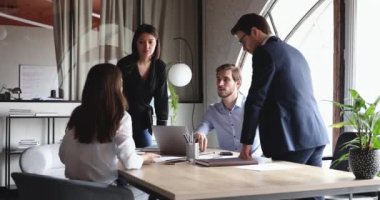 Modern ofiste çeşitli profesyonel iş adamları beyin fırtınası yapıyor.