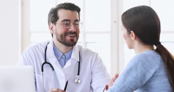 Ευτυχισμένος επαγγελματίας γενειοφόρος άντρας θεραπευτής συμβουλεύεται γυναίκα ασθενή στο check up. — Αρχείο Βίντεο