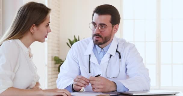Médecin généraliste concentré expliquant les questions d'assurance médicale au patient . — Video
