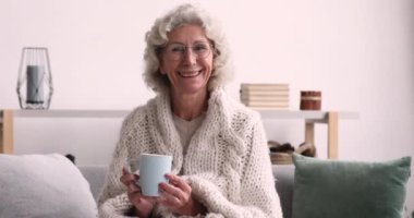 Huzurlu, mutlu, orta yaşlı, elinde kahve olan olgun bir kadın..