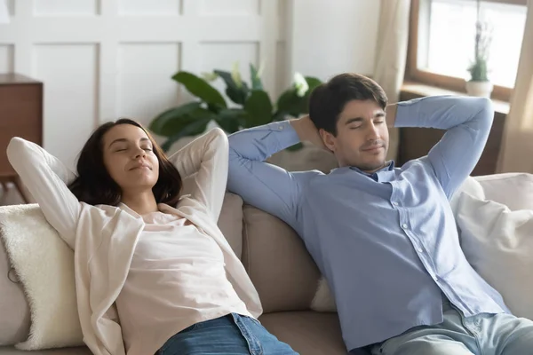 Расслабленная пара отдыхает на диване дома, мечтая — стоковое фото