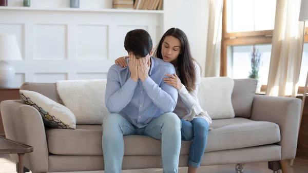 Jovem mulher abraço conforto chateado marido em casa — Fotografia de Stock