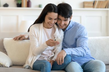 Mutlu çift evde akıllı telefon kullanarak rahatlıyor.