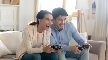 Genç çift evde video oyunu oynuyor.