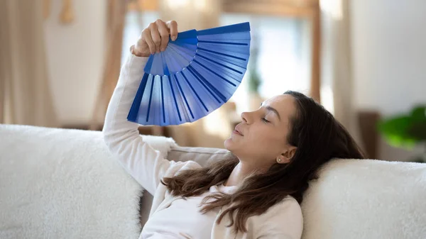 Overheated young woman breathe fresh air from waver — Stock Image Overheated young woman breathe fresh air from waver Stock Image