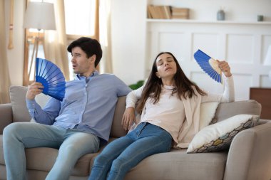 Hasta çift sıcak havadan muzdarip yelpaze kullanır.