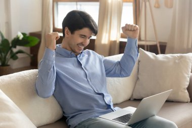 Heyecanlı beyaz adam dizüstü bilgisayarından hoş bir e-posta alıyor.