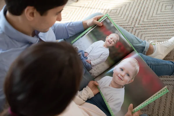 Les jeunes couples aiment les photos d'enfants d'enfance dans l'album — Photo