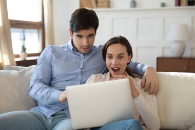 Genç çift dizüstü bilgisayardaki beklenmedik haberlere hayran kaldı.