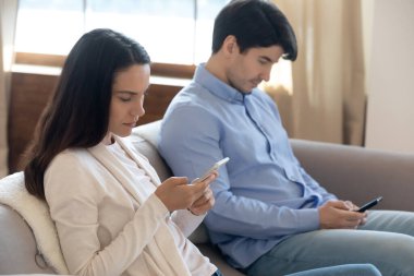Hafta sonları evde cep telefonu bağımlısı genç bir çift.