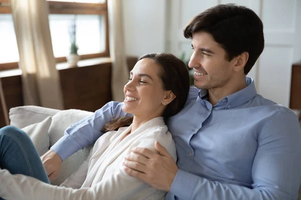 Lächelndes junges Paar entspannt sich auf der Couch — Stockfoto