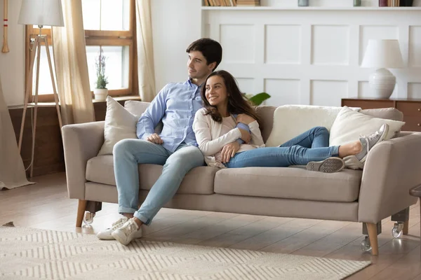 Happy young couple relax on couch in new apartment — Stock Photo, Image