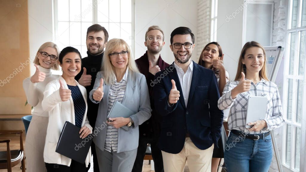 Excited group of diverse businesspeople showing thumbs up gesture.