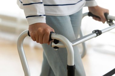 Yürüyen çerçeveyi tutan yaşlı engelli kadının yakın görüntüsü