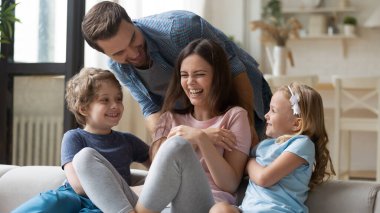 Küçük çocukları olan neşeli bir aile evde oynuyor.