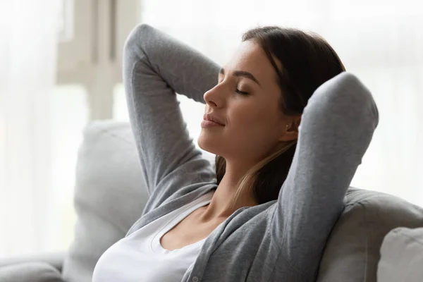 Woman puts hands behind head enjoy relaxation meditation at home — Stock Photo, Image