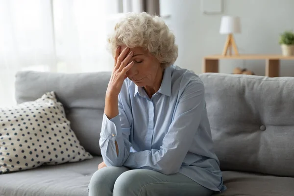 Elderly woman lost in sad thoughts feels miserable and lonely — Stock Photo, Image