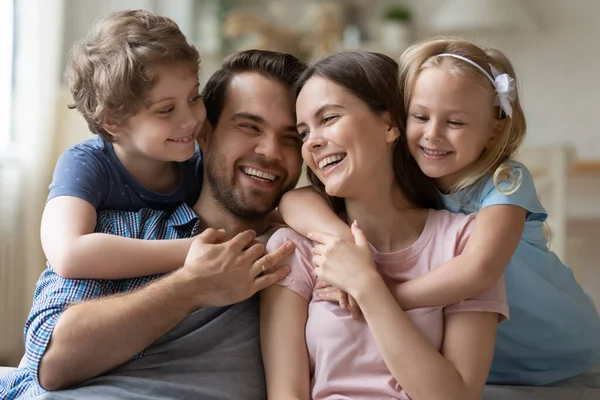 Küçük çocuklu mutlu bir aile evde rahatlar. — Stok fotoğraf