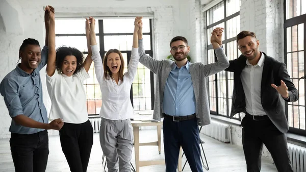 Excited diverse business people celebrating success, holding raised hands — Stock Photo, Image