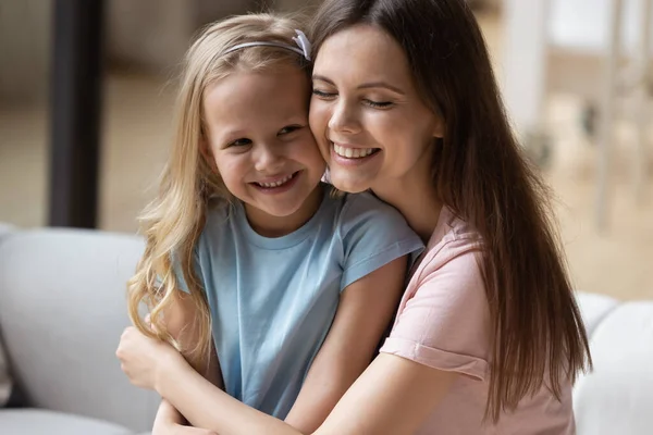 Щаслива мама і маленька дочка обіймаються вдома — стокове фото