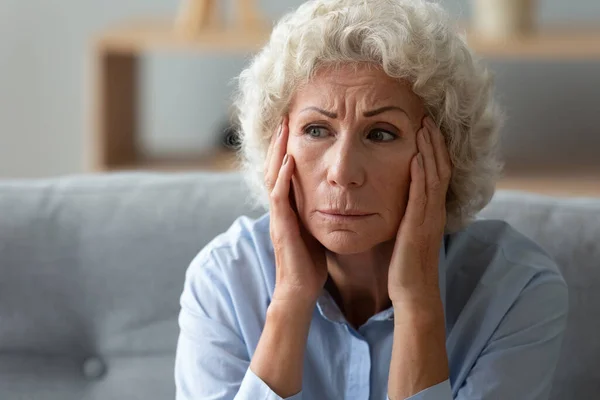 Close up worried elderly 70s woman deep in sad thoughts — Stock Photo, Image