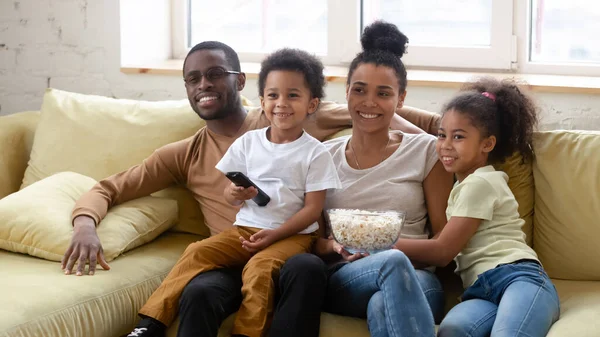 Volledig Afrikaans gezin brengen weekend thuis tv kijken — Stockfoto