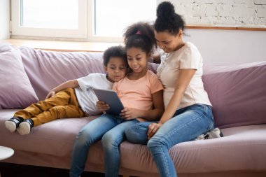 Afrikalı anne çocuklarla boş zamanlarını tablet aletlerle geçiriyor.