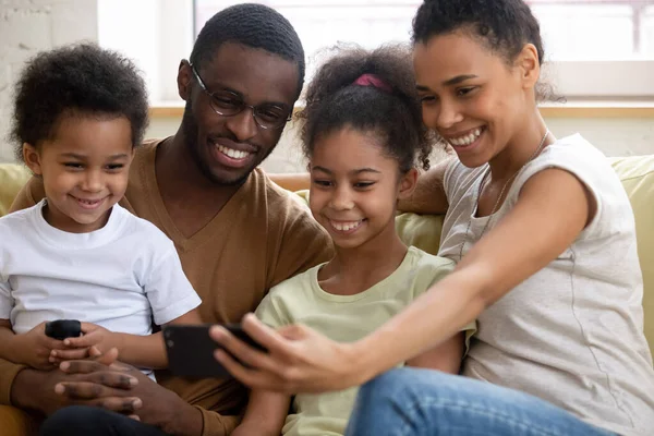 Familia africana con niños viendo videos divertidos en el teléfono inteligente — Foto de Stock