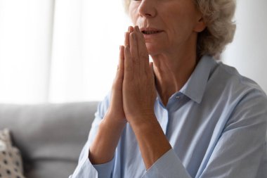 Yaşlı kadın avuç içlerini birleştirdi ve içeride dua etti.