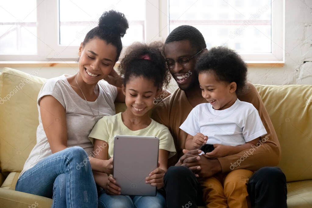 African family with kids spend free time using tablet device