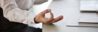 Sakin bir iş kadını masasına oturup meditasyon pratiği yapar.