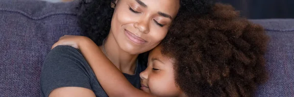 Africano mamma abbraccio piccola figlia sedersi su divano godere momento — Foto Stock