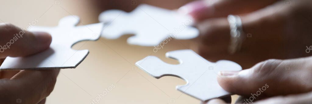 Closeup view hands of multiethnic people holding pieces of puzzle