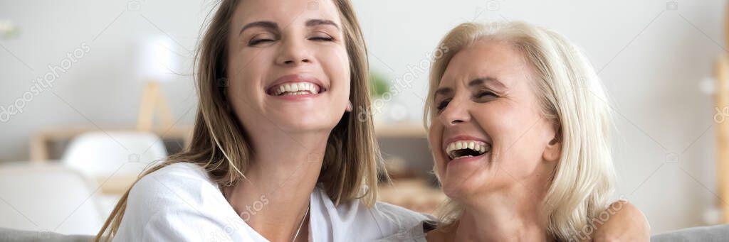 Daughter and aged mother enjoy communication joking having fun indoors