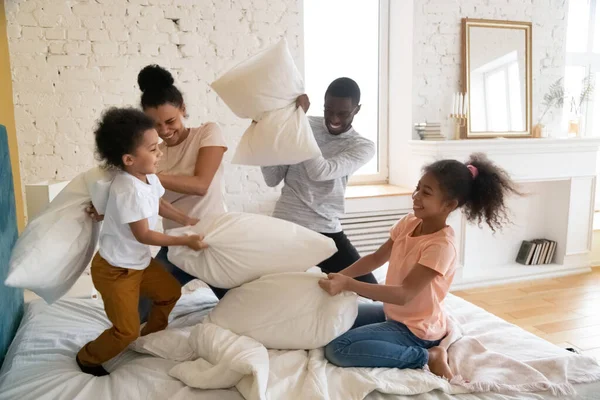 Keluarga Afrika menghabiskan waktu di kamar tidur bertengkar dengan bantal — Stok Foto