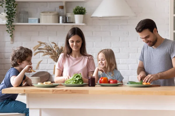 Gülümseyen genç aile mutfakta birlikte yemek pişiriyor. — Stok fotoğraf