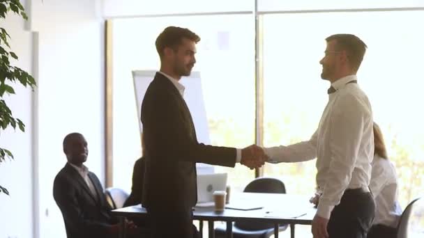 Boss shaking hands welcoming new employee during briefing in boardroom — Stock Video