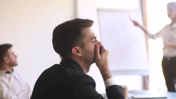 Скучный работник зевает во время семинара или презентации в офисе — стоковое видео